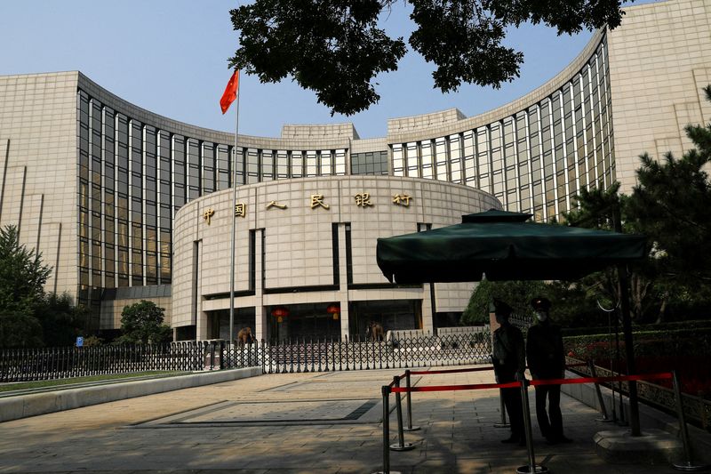 Paramilitary police officers stand guard in front of the headquarters of the People's Bank of China, the central bank (PBOC), in Beijing